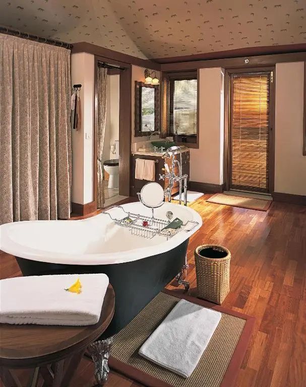 Luxuriöses Badezimmer mit freistehender Badewanne und Holzboden