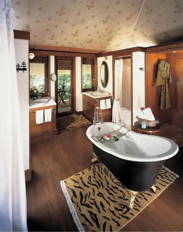 Elegantes Badezimmer mit freistehender Wanne und Deko-Teppichen