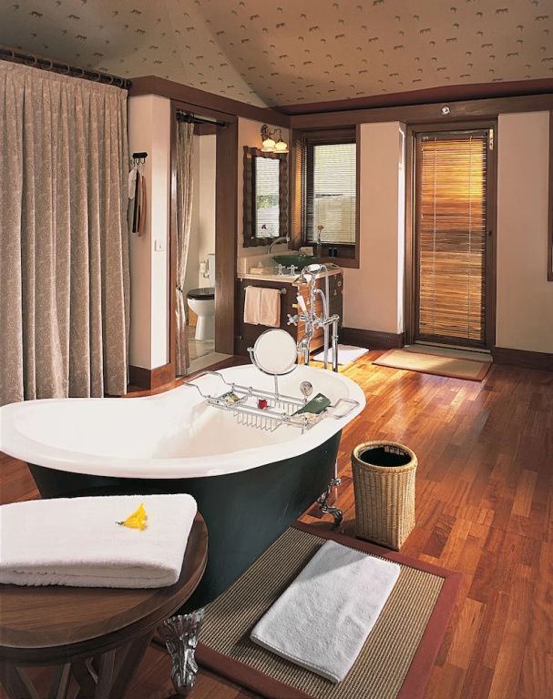 Luxuriöses Badezimmer mit freistehender Badewanne und Holzboden