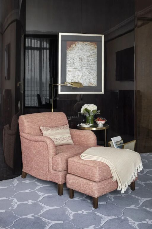Gemütliche Sitzecke mit Sessel, Ottomane und edlen Dekorationen in einem Hotelzimmer.