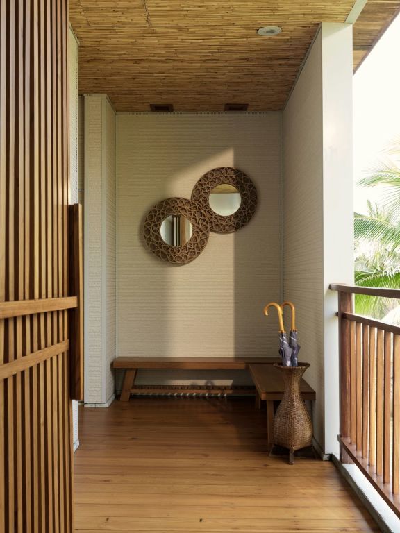 Ruhige Terrasse mit Holzdielen und dekorativen Spiegeln an der Wand.
