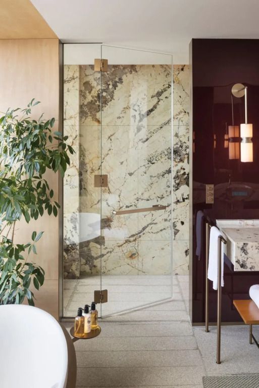 Edle Dusche mit Marmorverkleidung und eleganter Glasabtrennung.