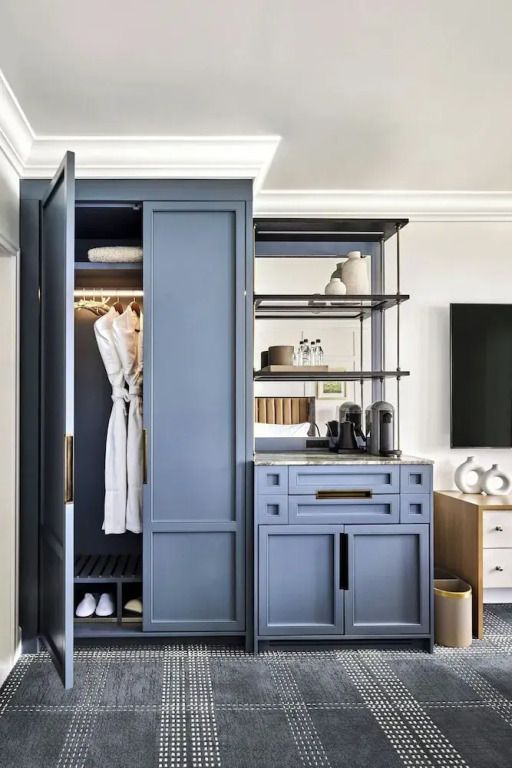 Moderner Schrank mit Bademänteln und Kaffeemaschine im Deluxe Zimmer