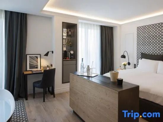 Elegantes Schlafzimmer mit Doppelbett und Schreibtisch in der Suite des Hotels Serras Barcelona