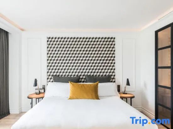 Modernes Doppelbett mit stilvollem Kopfteil und Kissen in der Suite des Hotels Serras Barcelona
