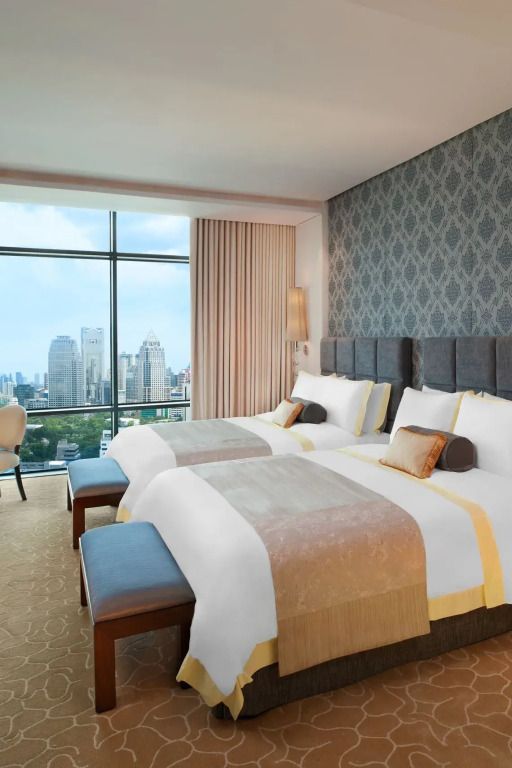 Gästezimmer mit zwei Doppelbetten und Panoramafenster mit Blick auf Bangkok