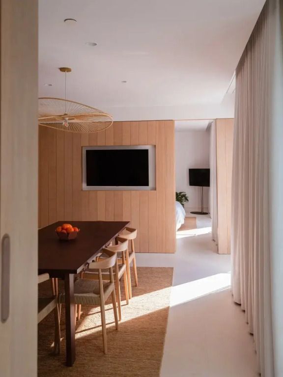 Elegantes Esszimmer mit Holzverkleidung und großem Tisch im The Standard Ibiza.