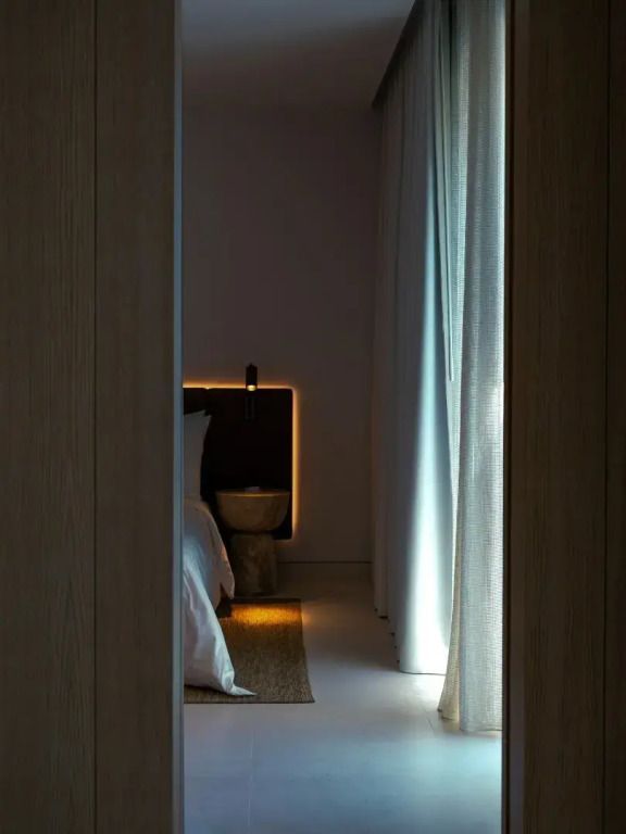 Stilvolles Schlafzimmer in der Plaza Suite mit dezenter Beleuchtung und Vorhängen