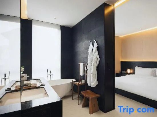 Luxuriöses Badezimmer mit freistehender Badewanne und flauschigen Bademänteln.
