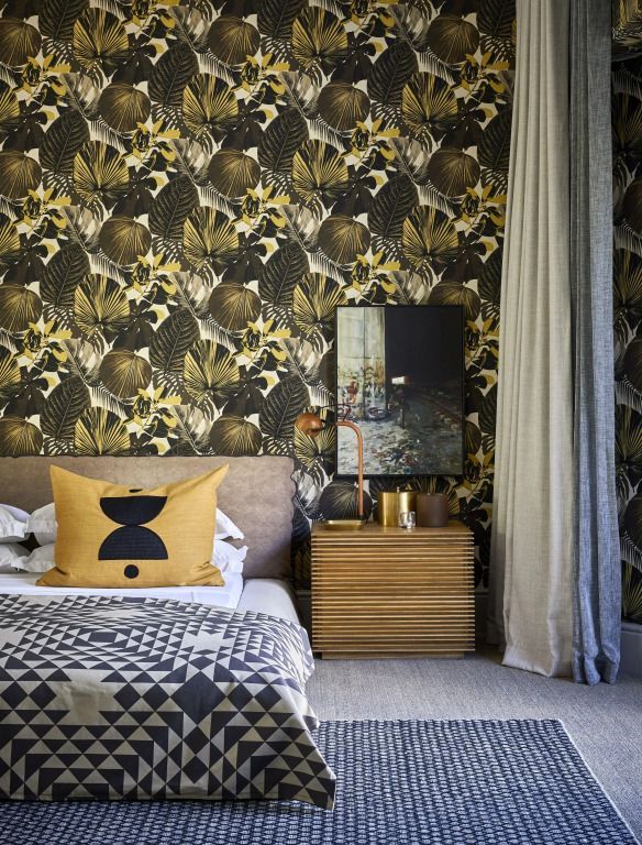 Schlafzimmer mit gemusterter Tapete und stilvollen Dekorationen