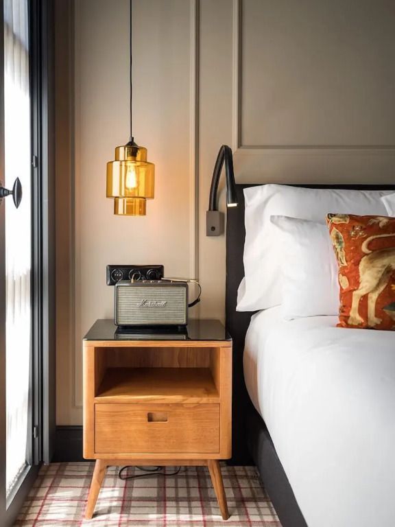 Nachttisch mit Hängelampe und Dekoration im Zimmer