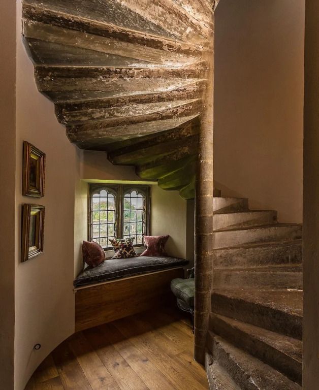 Historische Wendeltreppe mit Sitznische und gotischen Fenstern im Thornbury Castle.