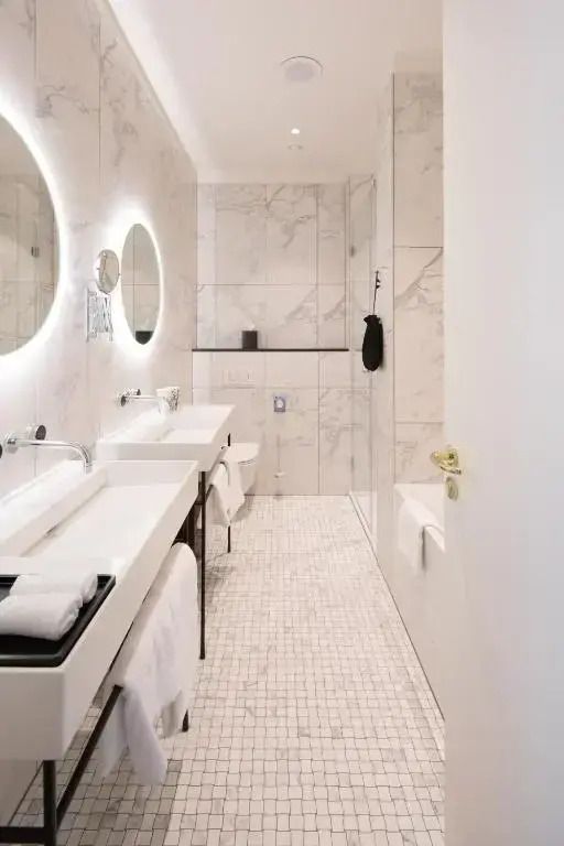 Luxuriöses Badezimmer mit Doppelwaschbecken und beleuchtetem Spiegel