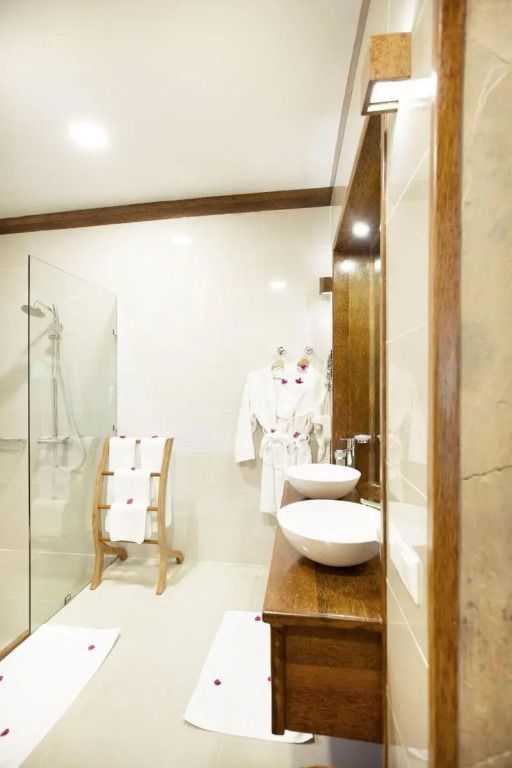 Elegantes Badezimmer mit Holzdetails und moderner Dusche im Tulia Zanzibar Resort
