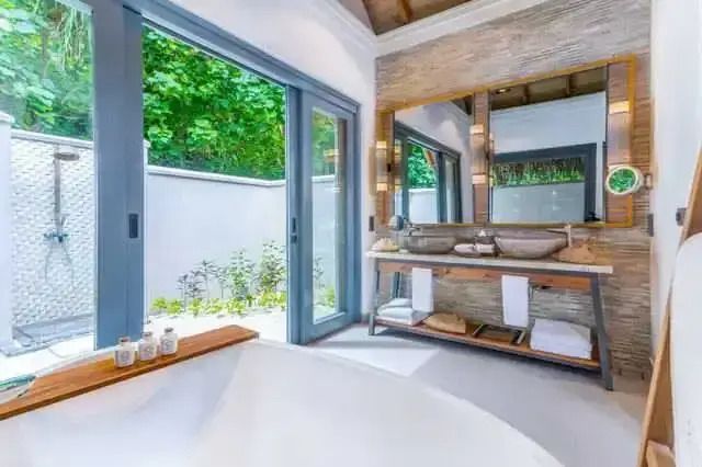 Luxuriöses Badezimmer mit direktem Zugang zum Garten und eleganter Ausstattung.