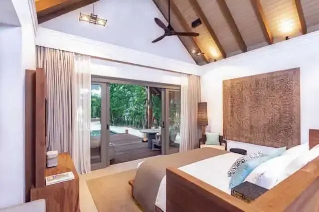 Schlafzimmer mit modernem Design, Holzbalkendecke und Zugang zur Terrasse mit Plunge Pool.