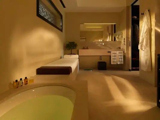 Luxuriöses Badezimmer mit eingelassener Badewanne und stilvoller Beleuchtung
