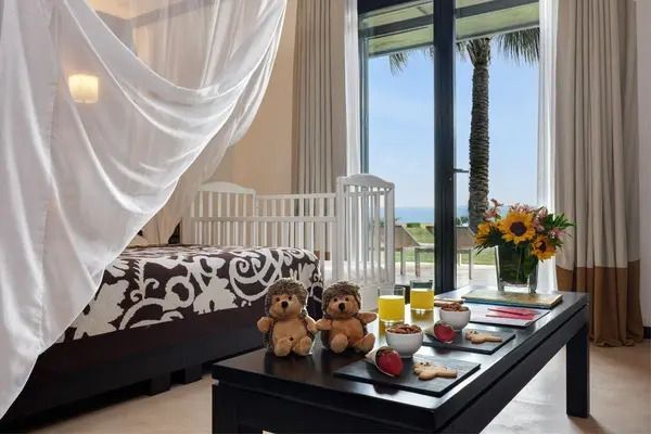 Familienzimmer mit Doppelbett, Kinderbett, Meerblick und Plüschtiere auf dem Tisch