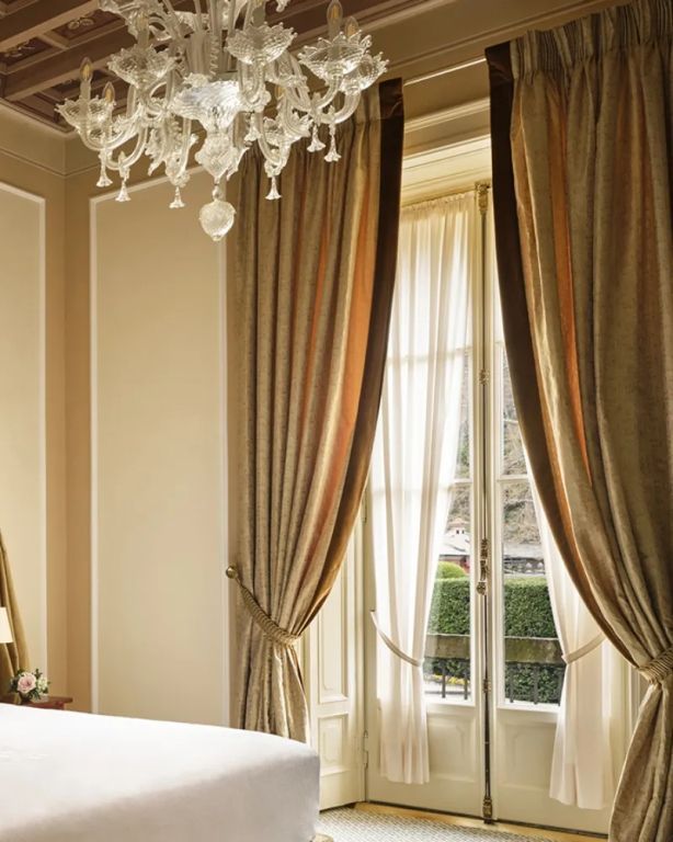 Elegant eingerichtetes Zimmer mit üppigen Vorhängen und Kristallleuchter