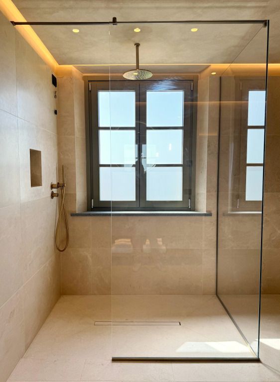 Luxuriöses Badezimmer mit großer Dusche und natürlichem Licht