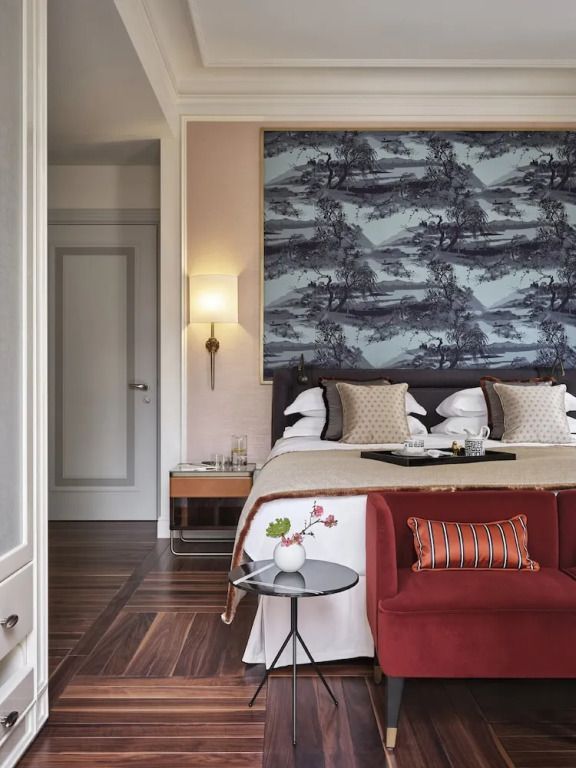Sitzecke im Deluxe Doppelzimmer mit rotem Sofa und stilvollem Tisch