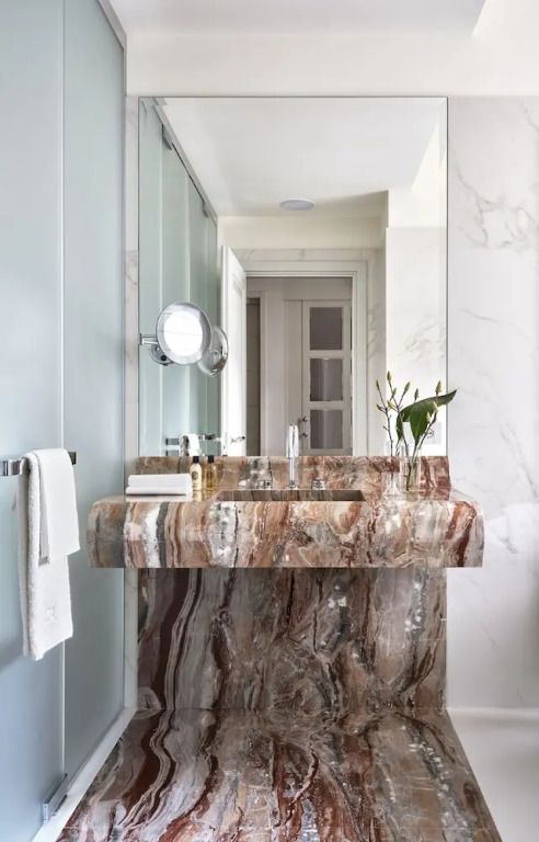 Luxuriöses Badezimmer mit Marmorwaschbecken und modernen Armaturen.