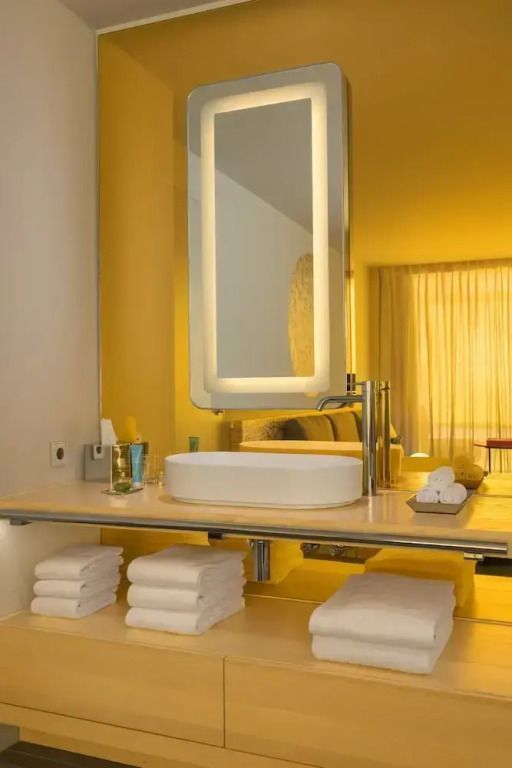 Badezimmer mit stilvollem Spiegel und eleganter Waschtischarmatur, weiche Beleuchtung.