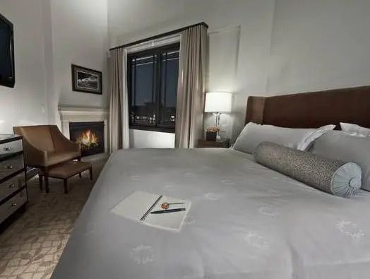 Luxuriöses Schlafzimmer mit Kamin, eleganter Einrichtung und großem Bett
