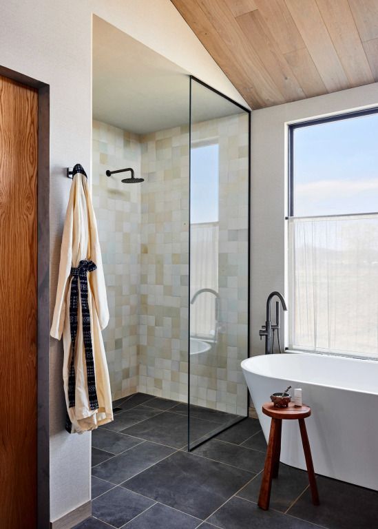 Moderne Dusche und freistehende Badewanne in elegantem Badezimmer