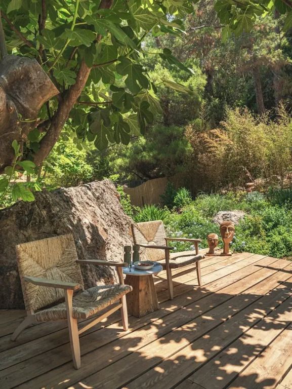 Sonniger Gartenbereich mit zwei Holstühlen und üppigem Grün
