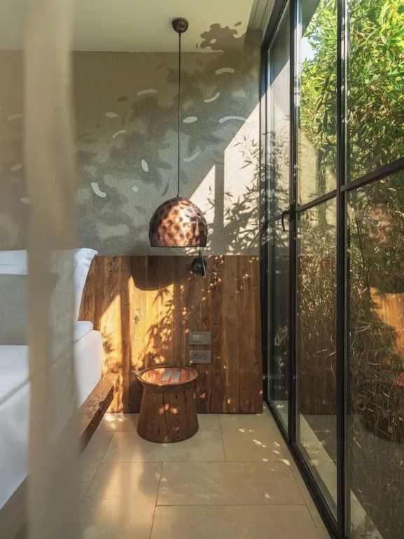 Sitzbereich neben bodentiefem Fenster mit natürlichem Lichteinfall und Wanddekor