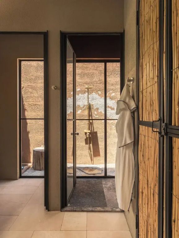 Flur mit Türen und künstlerischen Elementen aus Naturmaterialien in der Suite