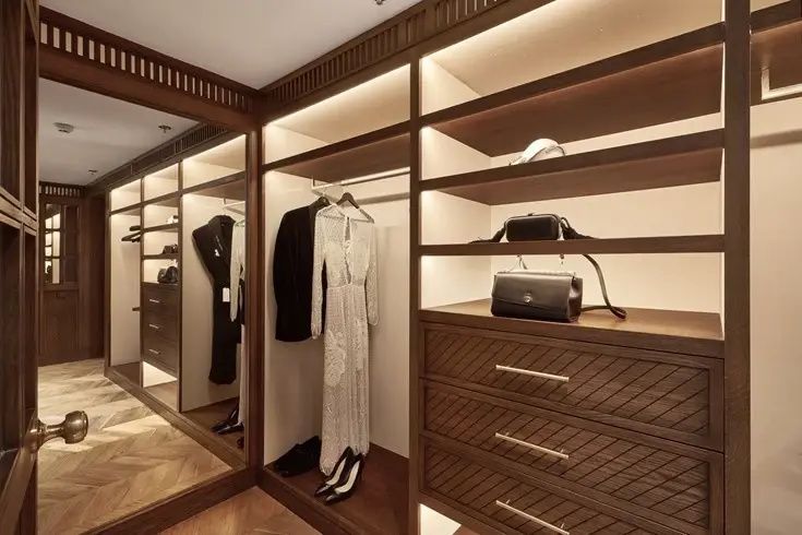Beleuchteter begehbarer Kleiderschrank aus Holz mit Kleidung und Schubladen