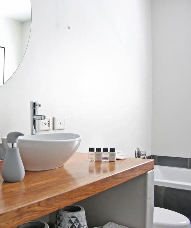 Modernes Badezimmer mit runder Waschschüssel und Pflegeprodukten