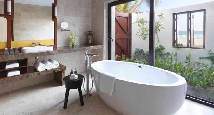 Modernes Badezimmer mit freistehender Badewanne und Gartenblick