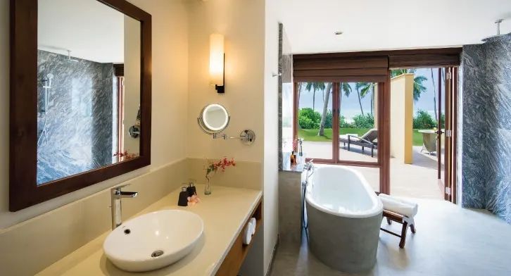 Modernes Bad mit freistehender Wanne und Ausblick auf tropische Gärten