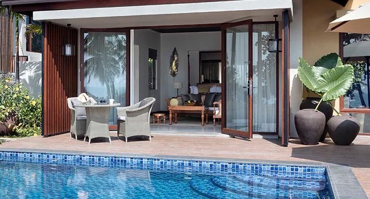 Offene Terrasse mit Möbeln und Poolzugang in einer luxuriösen Villa