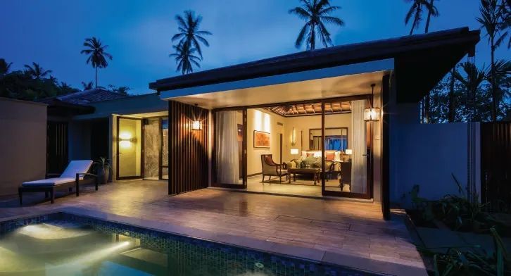 Abendstimmung in einer modernen Villa mit Poolbeleuchtung und tropischem Flair