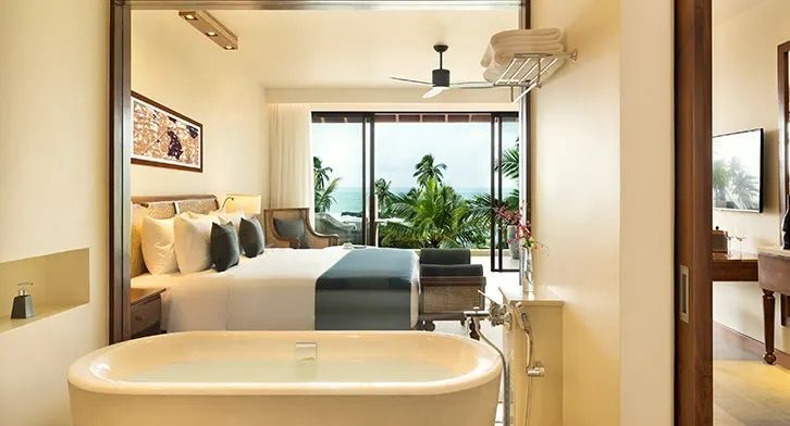 Luxuriöses Zimmer mit freistehender Badewanne und Blick auf das Meer