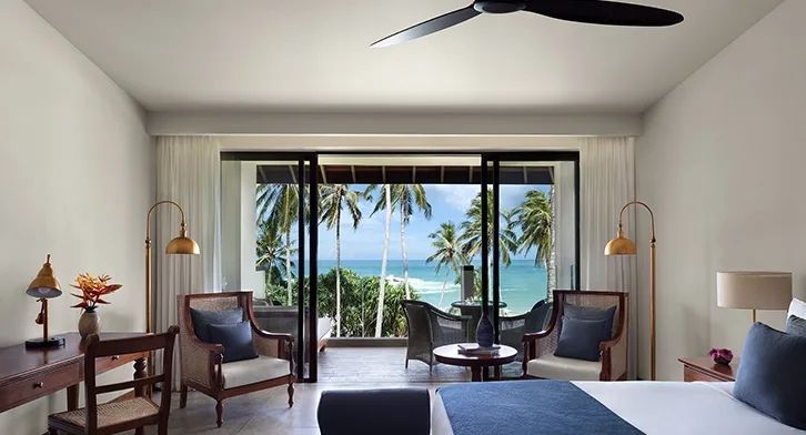 Zimmer mit Meerblick und Sitzbereich vor großen Glasfenstern
