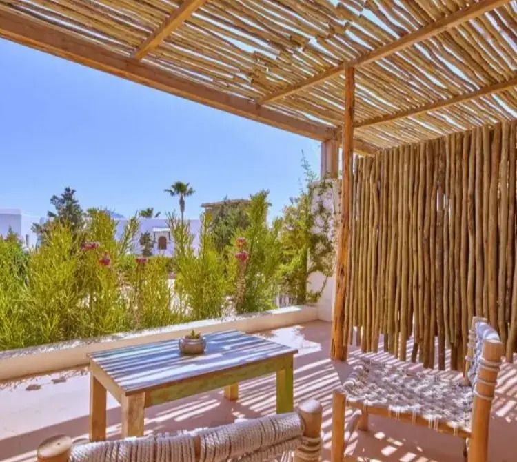 Entspannte Terrasse mit Schatten spendendem Pergola und gemütlichen Sitzgelegenheiten.