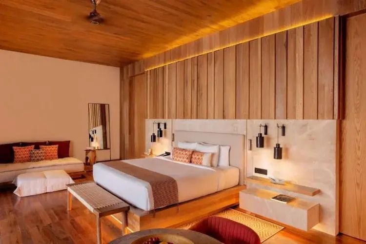 Elegantes Schlafzimmer mit Doppelbett und moderner Holzverkleidung im Banyan Tree Mayakoba.