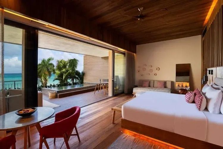 Suite mit offener Terrasse und Ausblick auf Palmen und Meer im Banyan Tree Mayakoba.