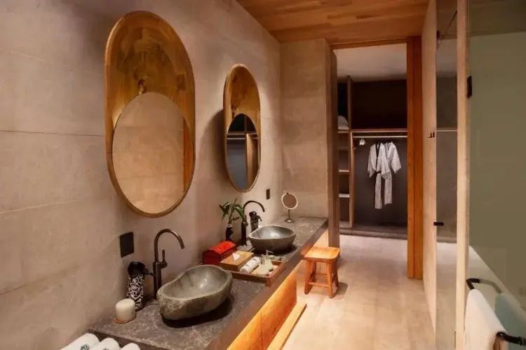 Luxuriöses Badezimmer mit Doppelwaschbecken und edlen Materialien im Banyan Tree Mayakoba.