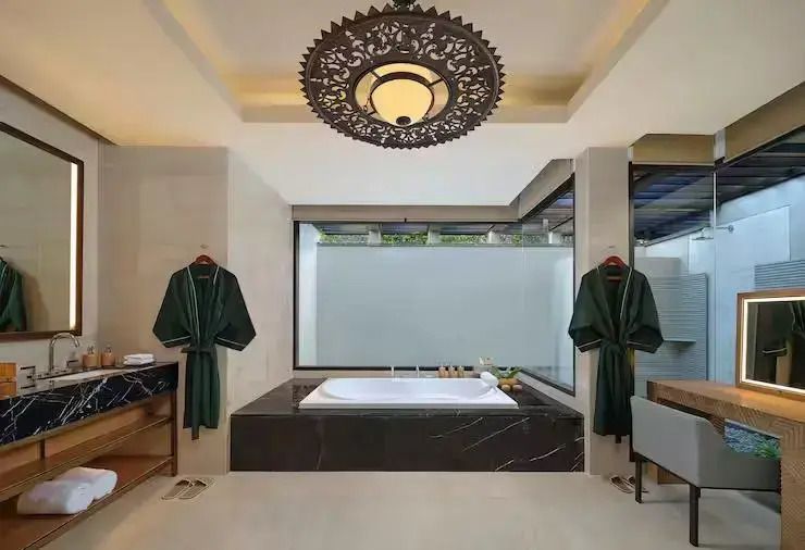 Badewanne und großer Kronleuchter im stilvollen Badezimmer