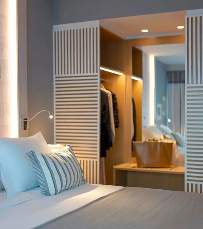 Gemütliches Bett im Zimmer mit offener Garderobe