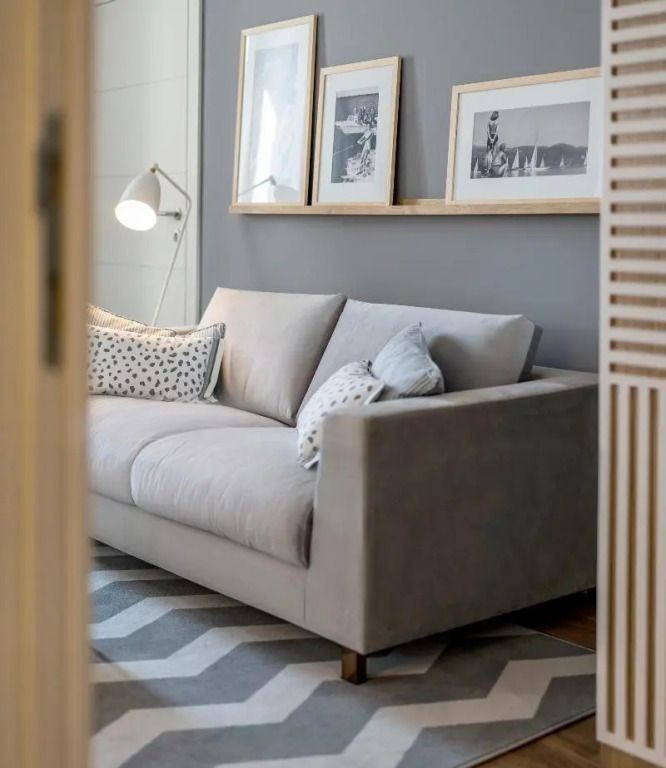 Elegantes Wohnzimmer mit grauem Sofa und moderner Kunst an der Wand