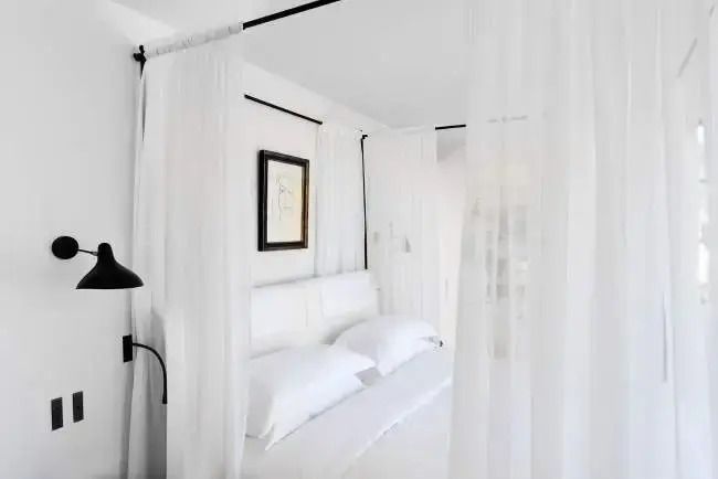 Blick auf ein luxuriöses Baldachinbett mit weißen Vorhängen