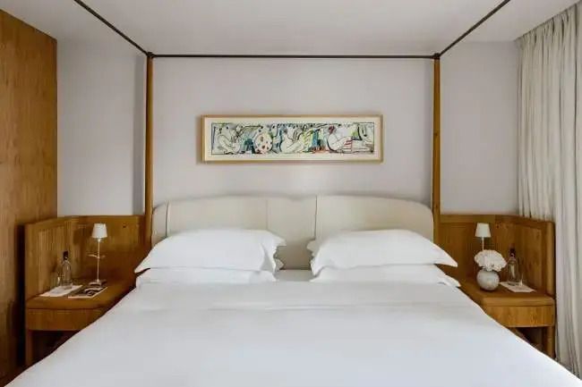 Luxuriöses Schlafzimmer mit stilvollem Kunstwerk über einem King-Size-Bett