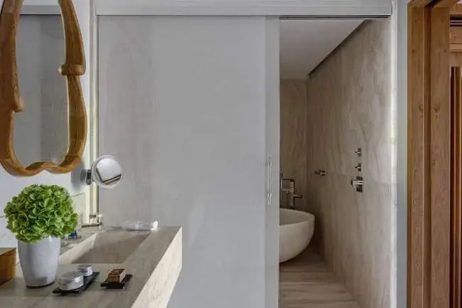 Elegantes Badezimmer mit Natursteinwaschbecken und freistehender Badewanne